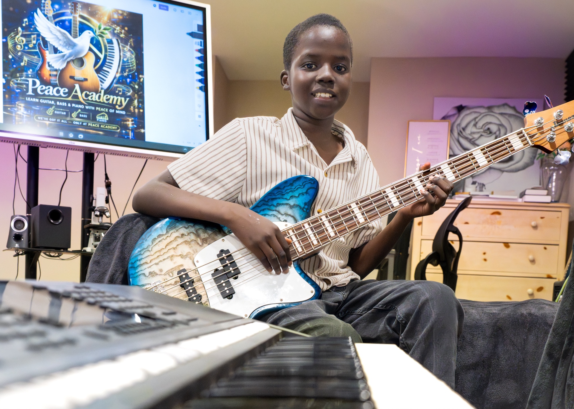 Moses learning bass guitar at Peace Academy in Aurora, Colorado