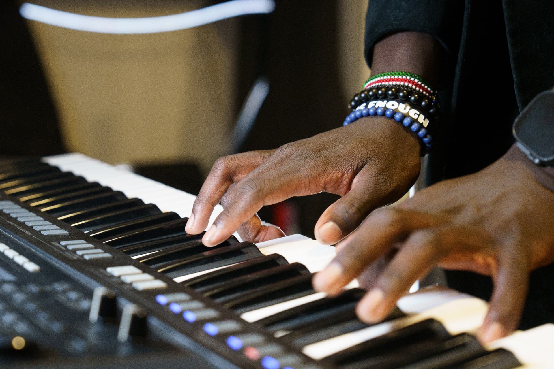 Close-up of hands playing piano keyboard during a lesson at Peace Academy of Music